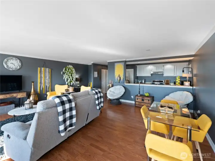 Dining area with glass table and cheery yellow chairs.