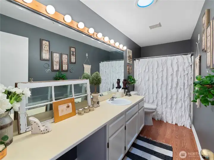 Guest bathroom offers great storage, large mirror, fresh paint and newer LVP flooring.