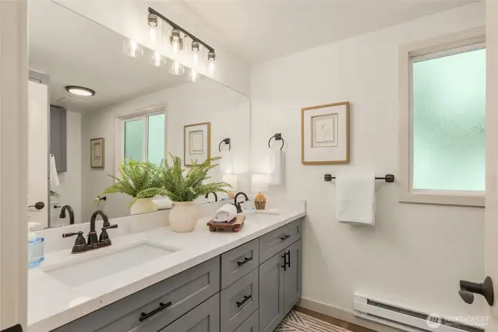 Beautifully remodeled upstairs bath featuring an expansive quartz vanity with abundant storage, modern fixtures, and a bright, clean design that comfortably serves the upstairs living spaces. Beautifully remodeled upstairs bath featuring an expansive quartz vanity with abundant storage, modern fixtures, and a bright, clean design that comfortably serves the upstairs living spaces.