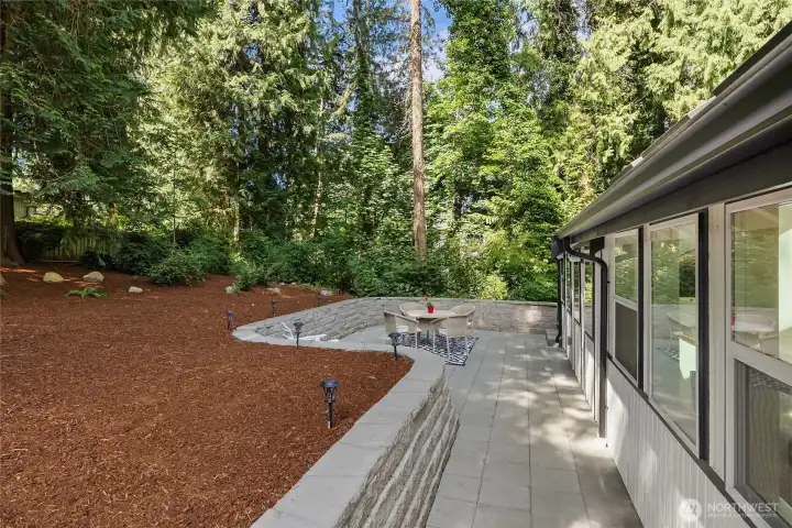 A spacious paver patio is thoughtfully integrated into the landscaped backyard, offering seamless access from the sunroom and kitchen while overlooking the home's serene, wooded surroundings. A spacious paver patio is thoughtfully integrated into the landscaped backyard, offering seamless access from the sunroom and kitchen while overlooking the home's serene, wooded surroundings.