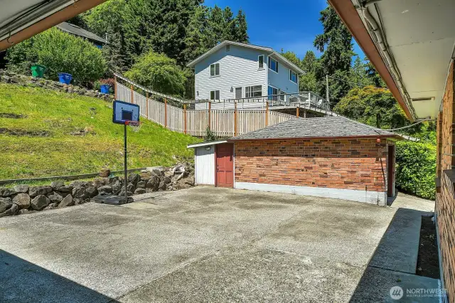 Imagine the summer parties you could have on this large patio! This photo also shows the one car garage with a garden shed, shop area, or extra storage space on the back.