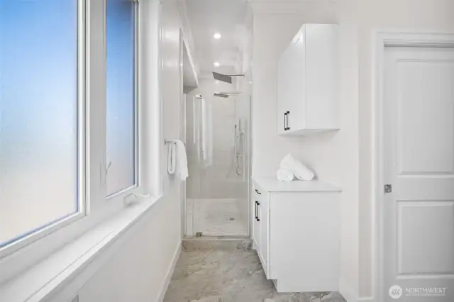Dual head walk-in shower with towel storage.