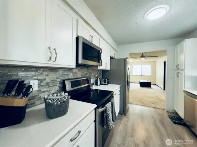 Updated kitchen, white cabinets with pull-out shelvings and pantry. Stainless steel appliances, easy access for entertaining.