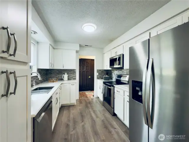 Updated kitchen, white cabinets with pull-out shelvings and pantry. Stainless steel appliances, easy access for entertaining.