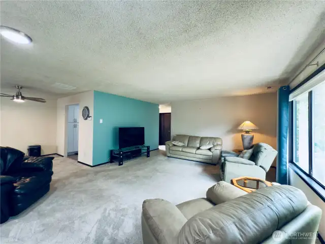View from living room to kitchen and entryway. Large window to the backyard.