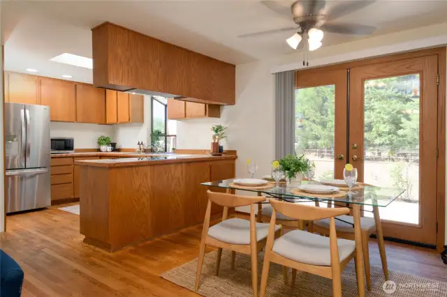 The kitchen and dining rooms enjoy oak cabinetry and flooring, a spacious pantry(left of photo), and generous counter space. The charming garden window in the kitchen frames peaceful outdoor views while bathing the space in natural light.