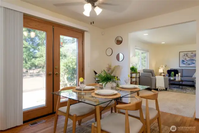 The dining area showcases rich hardwood floors and lovely French doors that open seamlessly to the back patio and yard, creating an ideal flow for indoor-outdoor living.