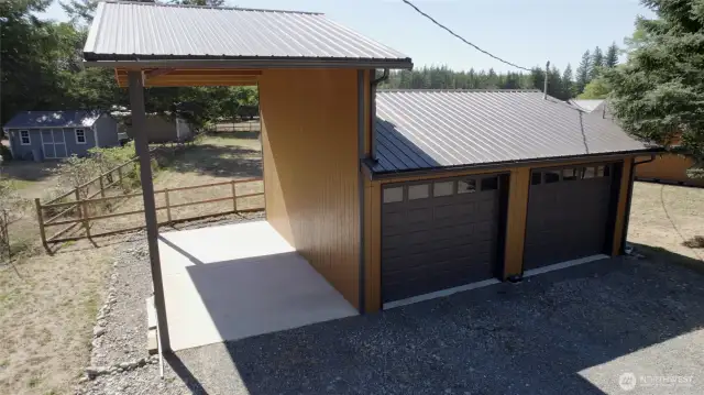 A versatile 2-car detached garage with metal roof doubles as a hobbyist’s workshop, complete with covered RV parking and a dedicated pad. Ideal for projects, toys, or extra storage needs.