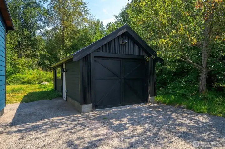 Finished garage with electricity and metal roof.