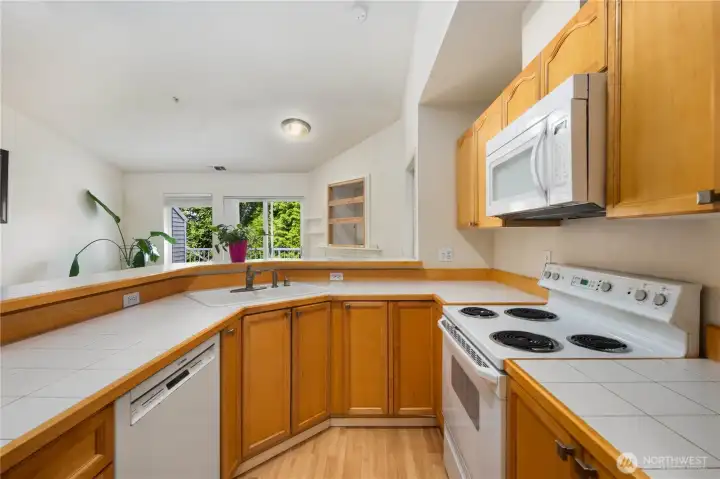 Kitchen: Functional kitchen with ample cabinetry, breakfast bar, and included appliances. Open sightlines to the living room and deck create a seamless flow for everyday living.