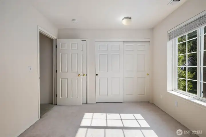 Second Bedroom: Bright second bedroom with large window, double closet, and versatile layout for guests, office, or flex space.