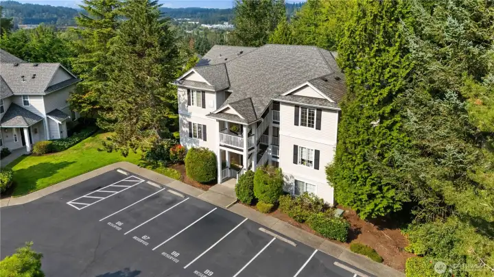 Drone View: Aerial view of the Woodinview community highlights lush surroundings, ample parking, and convenient access to nearby Bothell and Woodinville amenities.