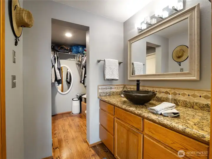 The primary suite full bath on the main level hhas the bathtub/toilet separate from the vanity area.