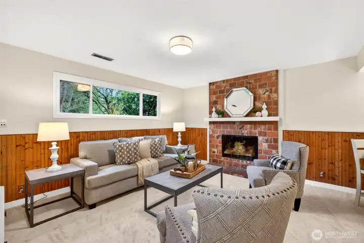 Head downstairs to a cozy, inviting lower level that feels made for movie nights, game days, and relaxed weekends at home. The brick fireplace and warm wood paneling create character you cannot replicate, and the large window brings in natural light while keeping the space private. With new carpet, it feels comfortable, quiet, and ready to become your favorite hangout zone.