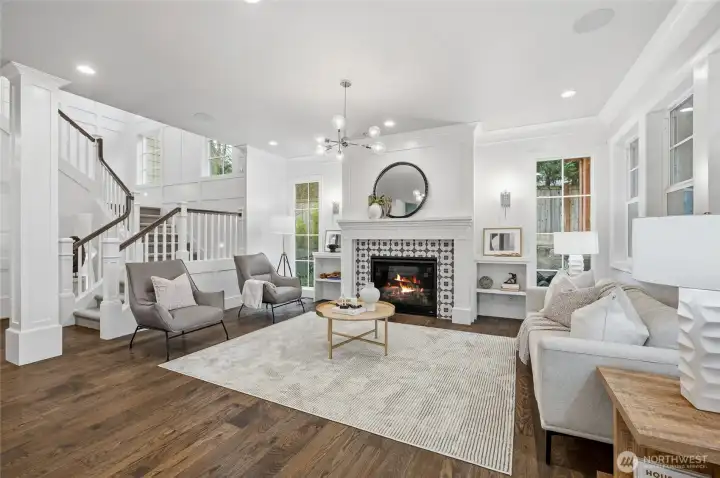 Stunning living room with fireplace and built-in speakers plus extra large windows for natural light.
