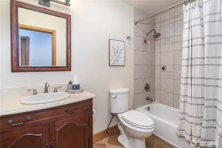 Full bath off hallway toward second bedroom and office.