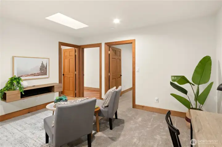 Additional living area is located down the hall from the other wing of the home. The door on the left is a full bathroom, hallway in the middle and then third bedroom on the right