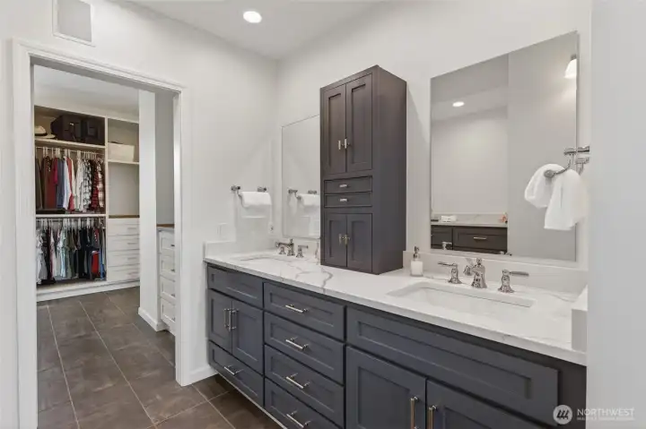 Primary dual sinks with granite countertops and in-cabinet outlets.