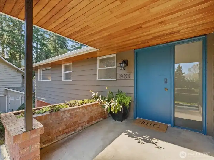The large covered entry with brick planting bed.