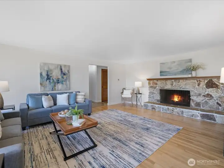 Very spacious living room with hardwood floors and wood burning fireplace.