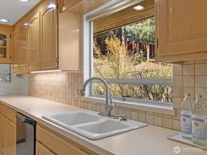 The pleasant Kitchen includes tiled backsplash, quality cabinetry and generous work space.