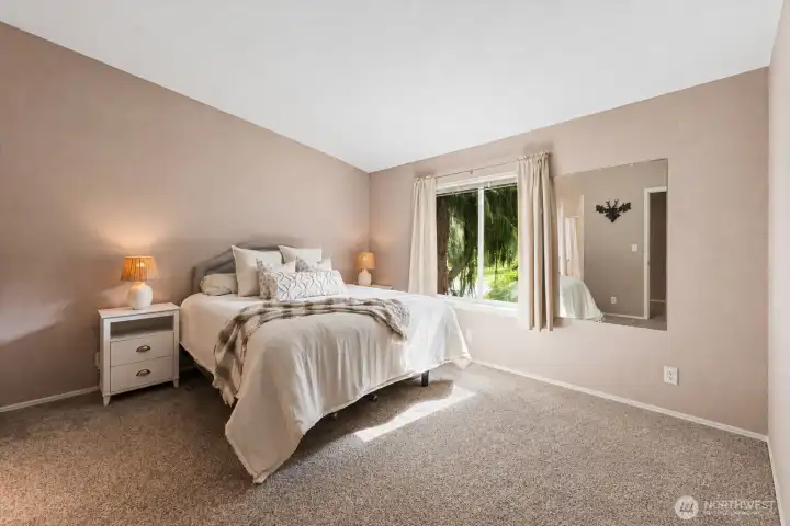 A spacious primary bedroom where soft, natural light filters in.