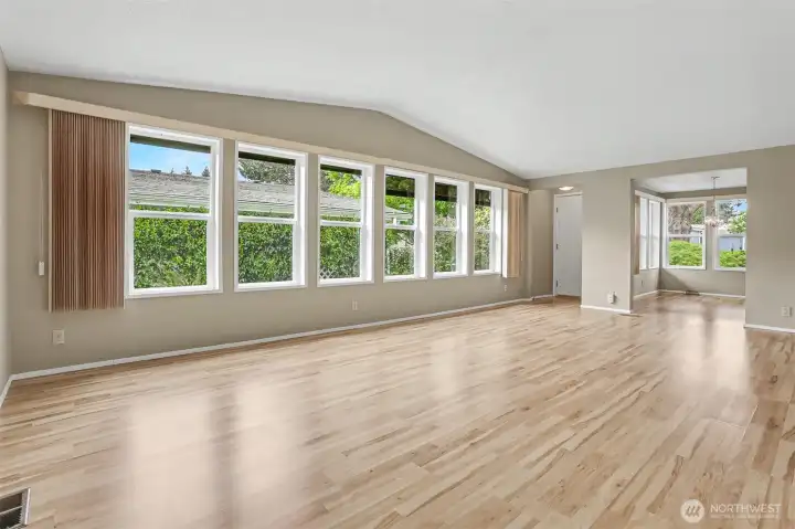 Formal living room has vaulted ceilings, laminate floors and opens to the office/den/bonus room.