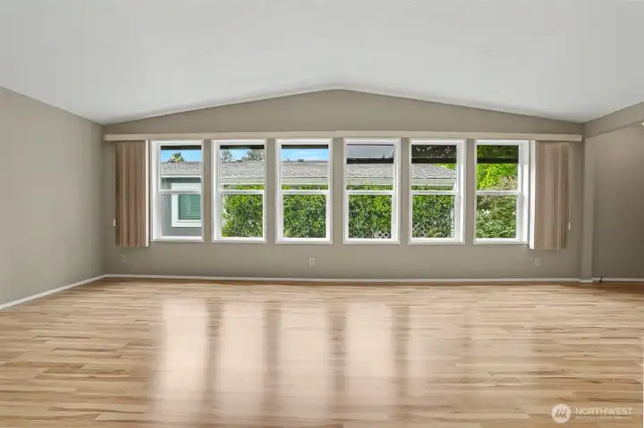 Formal living room has vaulted ceilings, laminate floors and opens to the office/den/bonus room.