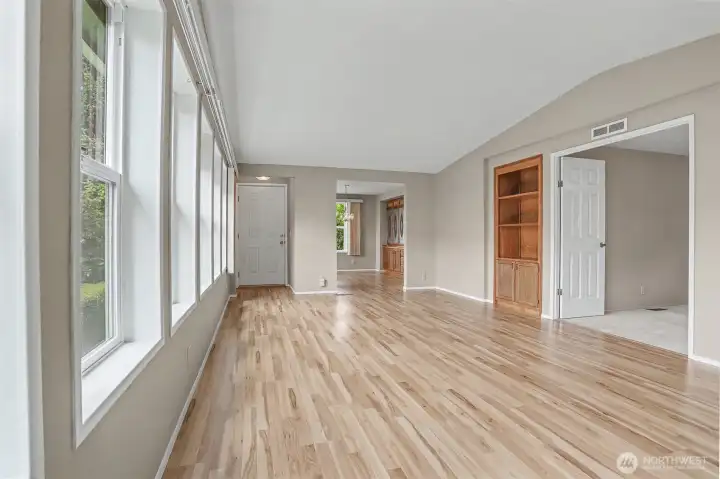 Formal living room has vaulted ceilings, laminate floors and opens to the office/den/bonus room.