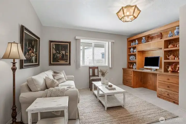 Den/office/bonus room has built in oak cabinets and desk space.  Opens to the formal living room. Virtually staged photo.