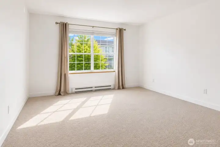 Retreat to the spacious primary bedroom with brand new carpet throughout