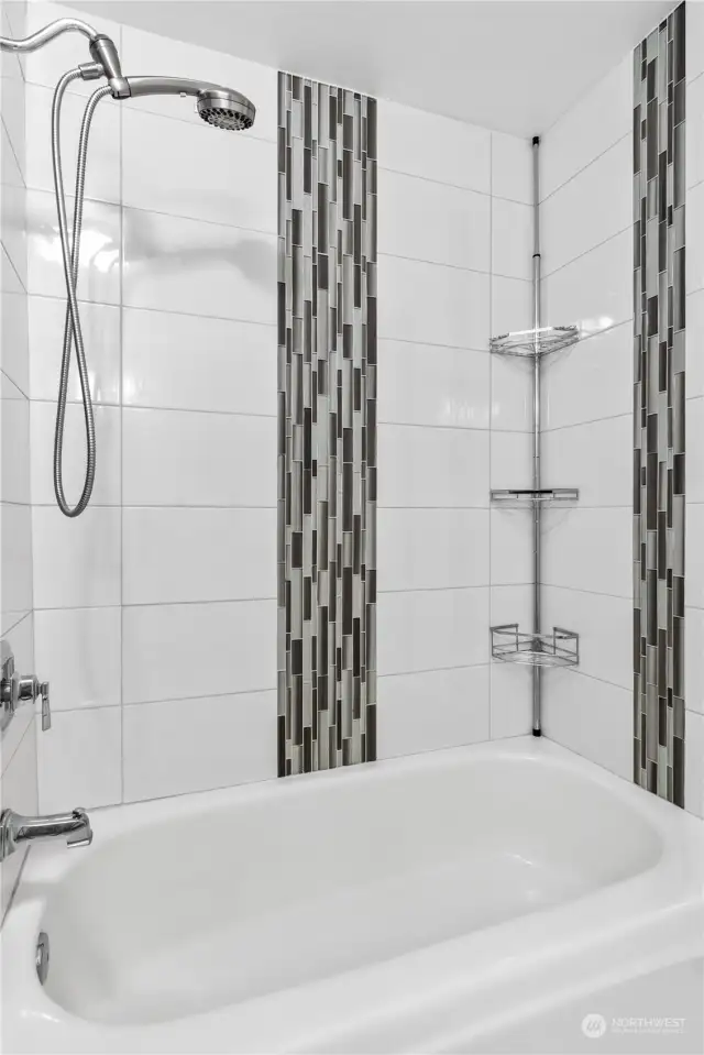 Beautifully tiled bathtub and shower upstairs.