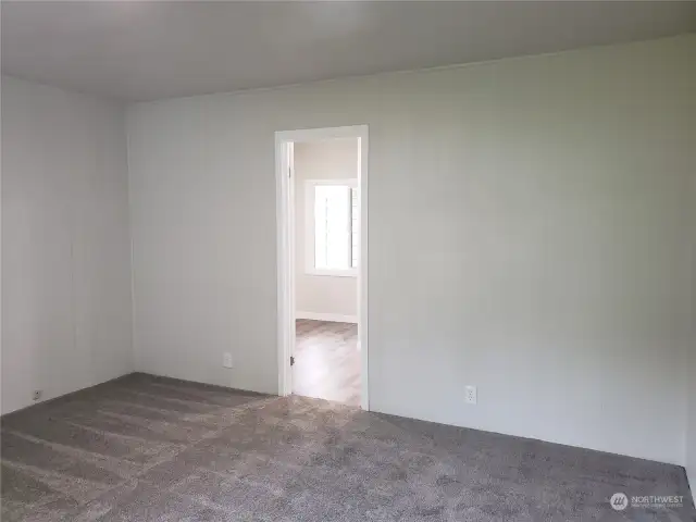 Spacious Primary Master Bedroom with Brand New Carpet, Paint, Showing Entry to the Bathroom.