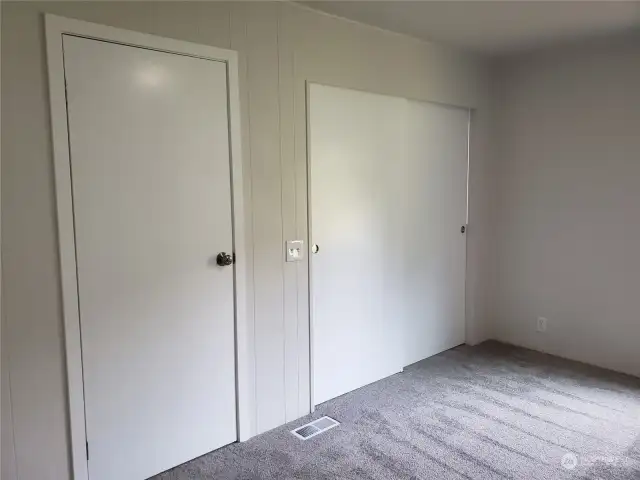 Another View of the Spacious Primary Master Bedroom with Brand New Carpet, Paint, Showing Entry Door and Walk In Double Door Closet.