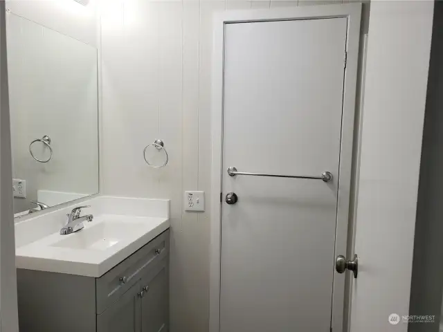 Large Main Guest Bathroom Showing Entry Door, New Vanity, Sink Faucet Paint and Vinyl Plank Flooring.