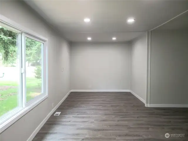 Another View of the Huge Extra Living Room Area of the Double Wide Home with All New Painted Walls, Trim, Vinyl Plank Flooring and Double Door Entry to the Front Covered Front Porch