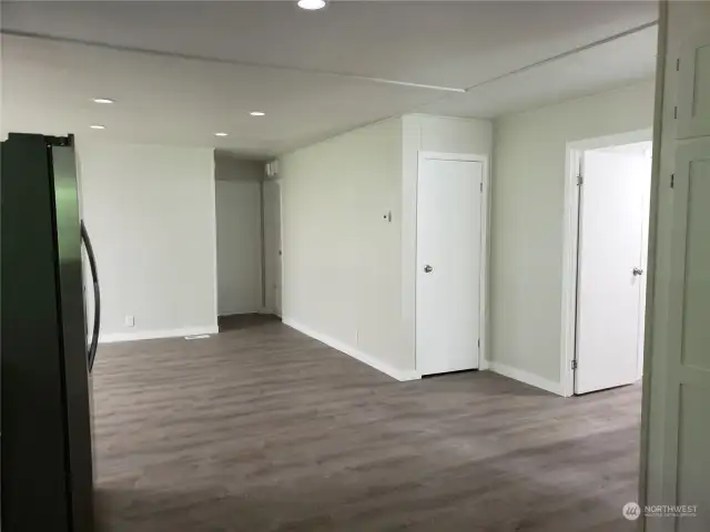 View from the Kitchen Showing Entry Closet, Recessed LED Lighting, Trim, and Vinyl Plank Flooring.