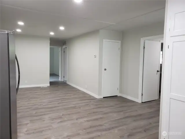 Different View of the Huge Open Kitchen with Vinyl Plank Flooring and Looking into The Extra Living Room