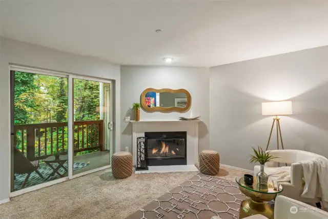 View of large living room with wood burning FP & large slider to back deck.