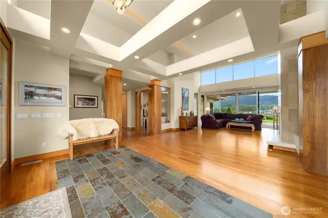 The dramatic entry ushers you toward the living room with a gas fireplace as the views draw you to the wall of windows beyond. The office is to the left of the living room and the second living room is to the right.  The two living spaces share a two-sided gas fireplace.