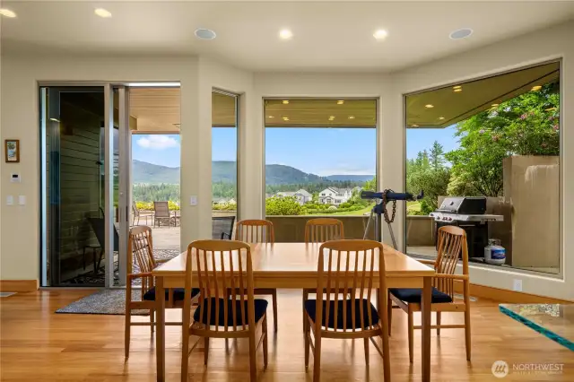 The informal dining area offers a warm, inviting space to gather, with a stunning wall of windows that frames the patio, manicured golf course, and majestic mountain views beyond. Perfect for everyday meals or entertaining, it seamlessly blends comfort with breathtaking scenery.