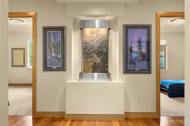 This exquisite water feature provides a soothing nature sound and is a focal point in the main hallway, flanked by two of the secondary bedrooms.