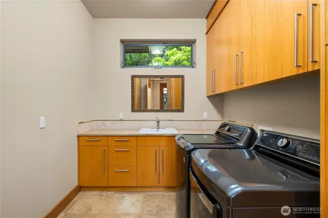 Spacious and functional, this utility room is designed for ultimate convenience with a utility sink and an abundance of cabinetry.