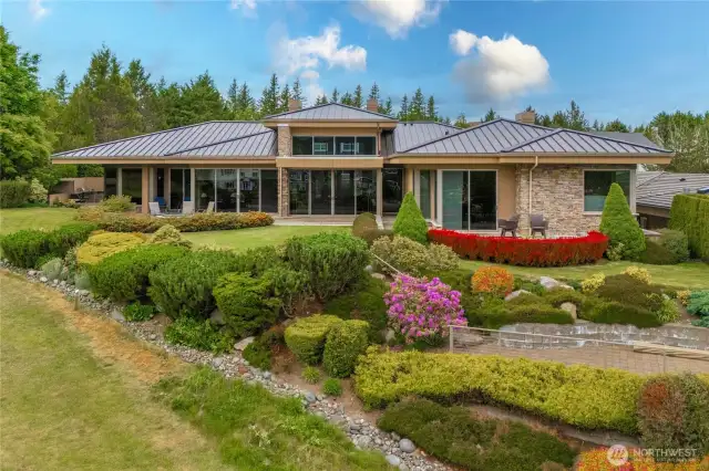 Ground-level view of the lush landscaping and patio spaces this home has to offer.
