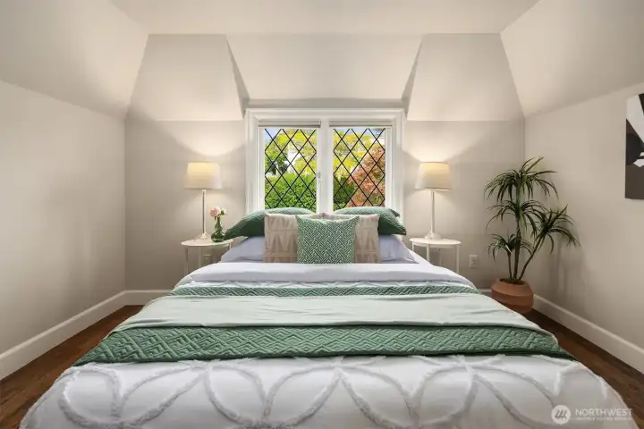 The third upstairs bedroom enjoys a leaded-glass outlook toward the front entry courtyard.