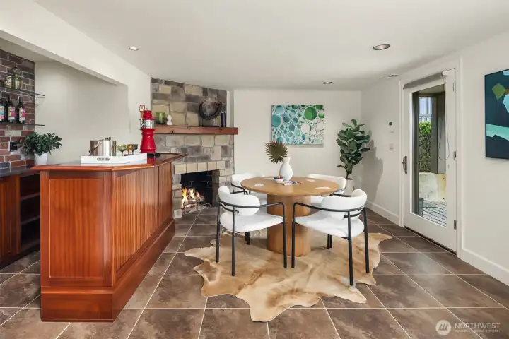 This fun bar area with gas fireplace is just to the left of the stairs from the main floor.  That fun TV hang-out area and ensuite bedroom are just behind us. The door leads to the back patios and yard....