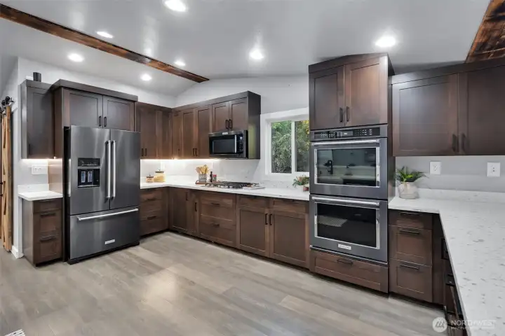 This gorgeous gourmet kitchen boasts of custom soft close cabinetry, under cabinet lighting, gas range and double oven.