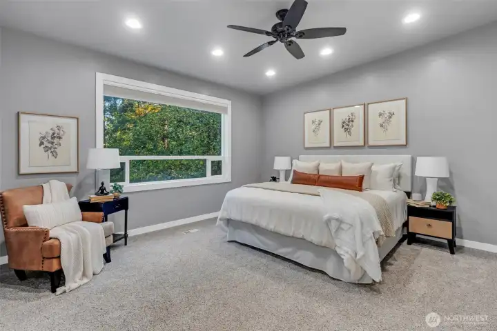 A generous primary bedroom with large picture window pouring natural light into the space.