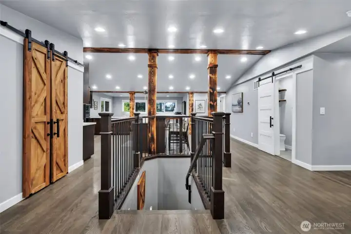 Hardwood floors on main level complemented by rich wood columns and sliding barn doors.