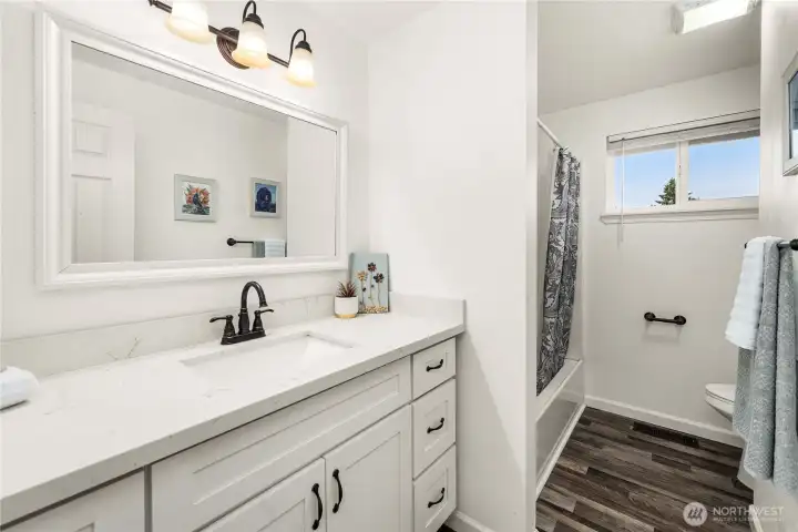 Hallway full bathroom with lovely quartz countertop.